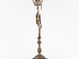 a brass candle holder with a clock on top of it