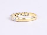 a yellow gold ring with white diamonds on a white background
