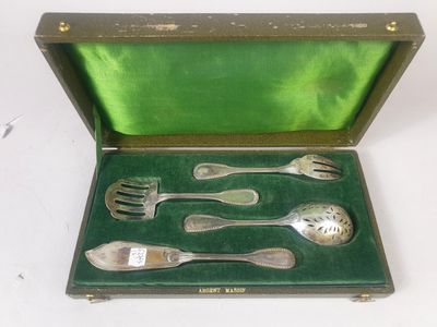 de l'argenterie dans un coffret doublé de velours vert sur un fond blanc