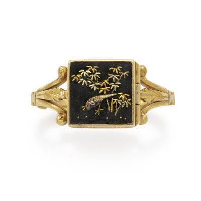 an image of a gold and black enamel ring with a bird on it