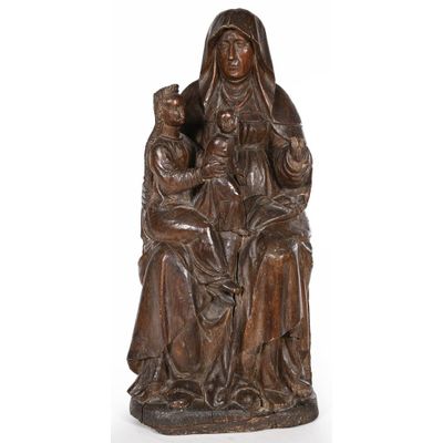 une statue en bois représentant une femme tenant un enfant et un chat dans ses bras