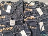 a close up of a pile of jeans with price tags on them