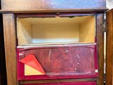 une armoire en bois dans laquelle se trouve un bout de papier rouge et jaune