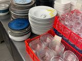many plates and cups on the counter in the kitchen