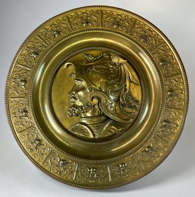 gold plate with a portrait of a man and a woman on it