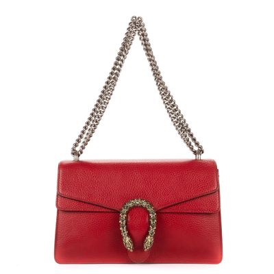 a red leather shoulder bag with a metal ring on the clasp