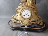 a gold clock sitting on top of a black table