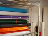 de nombreux rouleaux de papier coloré posés sur une étagère dans une pièce