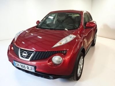 a red nissan juke parked in a white room