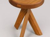 a close up of a small wooden stool with three legs