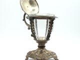 a silver cup with a spoon on top of it