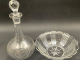a glass bowl and a glass decanter sitting on a table