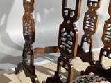 an image of a pair of antique carved wood tables on a tiled floor