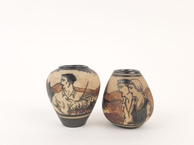 pair of vases with asian painting on them sitting on a white surface