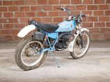 a blue and white motorcycle parked in front of a brick wall