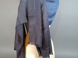 grey and blue scarf on a mannequin head against a gray background