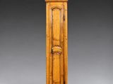 une vieille horloge de parquet en bois, avec un cadran blanc sur fond gris
