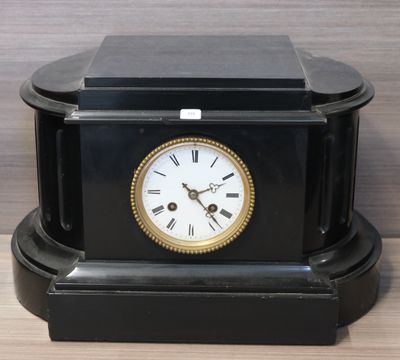 a black clock sitting on top of a wooden table