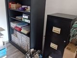 a black filing cabinet in the corner of a room