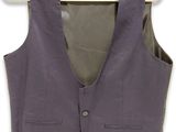 the vest is hanging on a hanger on a white wall