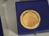 a gold coin sitting in a blue box on a table