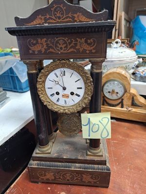 une horloge posée sur une table, avec une étiquette de prix dessus