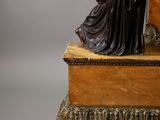 a statue of a woman sitting on top of a clock