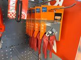 many pairs of pliers hanging on the wall of a store