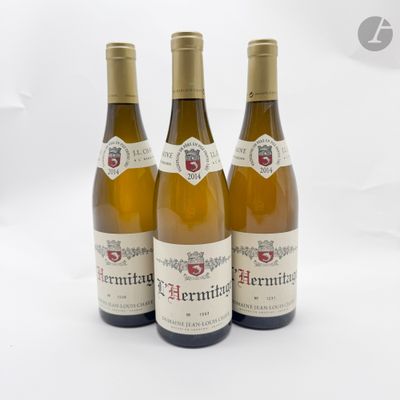 trois bouteilles de vin posées sur une table blanche