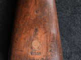 a close up of a wooden rifle on a black surface
