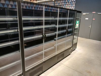 une grande vitrine comportant de nombreuses étagères dans le magasin