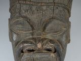 une image représentant un masque en bois dont le visage est sculpté dans le bois