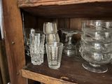many glasses and plates on a shelf in a room