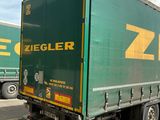 un camion vert garé sur le bord de la route