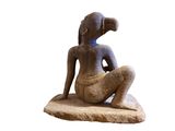 statue of a woman sitting on a rock with a cup in her hand