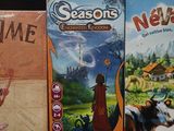 four board games are lined up on a black surface