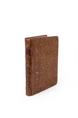 an old book with a brown cover sitting on top of a white surface