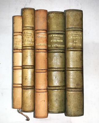 plusieurs vieux livres sont alignés sur une étagère, les uns à côté des autres
