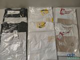 trois paires de t-shirts pour homme dans des sacs en plastique posés sur une table