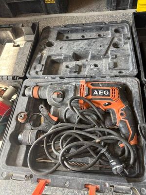 une perceuse électrique orange et noire ainsi que d'autres outils dans une mallette