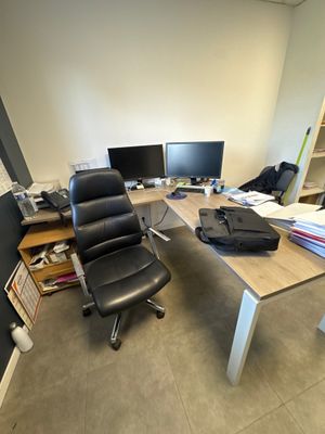 a desk with a chair and a computer on it