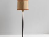 a floor lamp with a brown shade on top of it