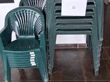 two green plastic chairs and a table in a room