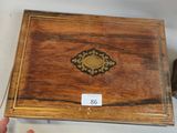 a small wooden box with a gold decoration on it