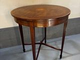 une petite table ronde avec un plateau en bois posée sur un sol bleu