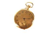 a gold pocket watch on a white surface with a white background
