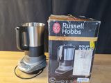 une boîte contenant une cafetière Russell Hobbs posée sur une table