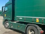 a green truck that is parked in a parking lot