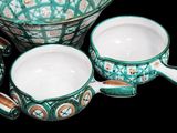 four bowls and two cups sitting next to each other on a table