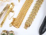 a lot of gold jewelry on a white surface